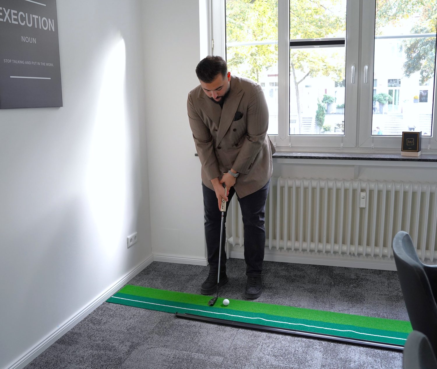 Sohrab Sayahi beim Putten im Büro von SAYAHI & PARTNER